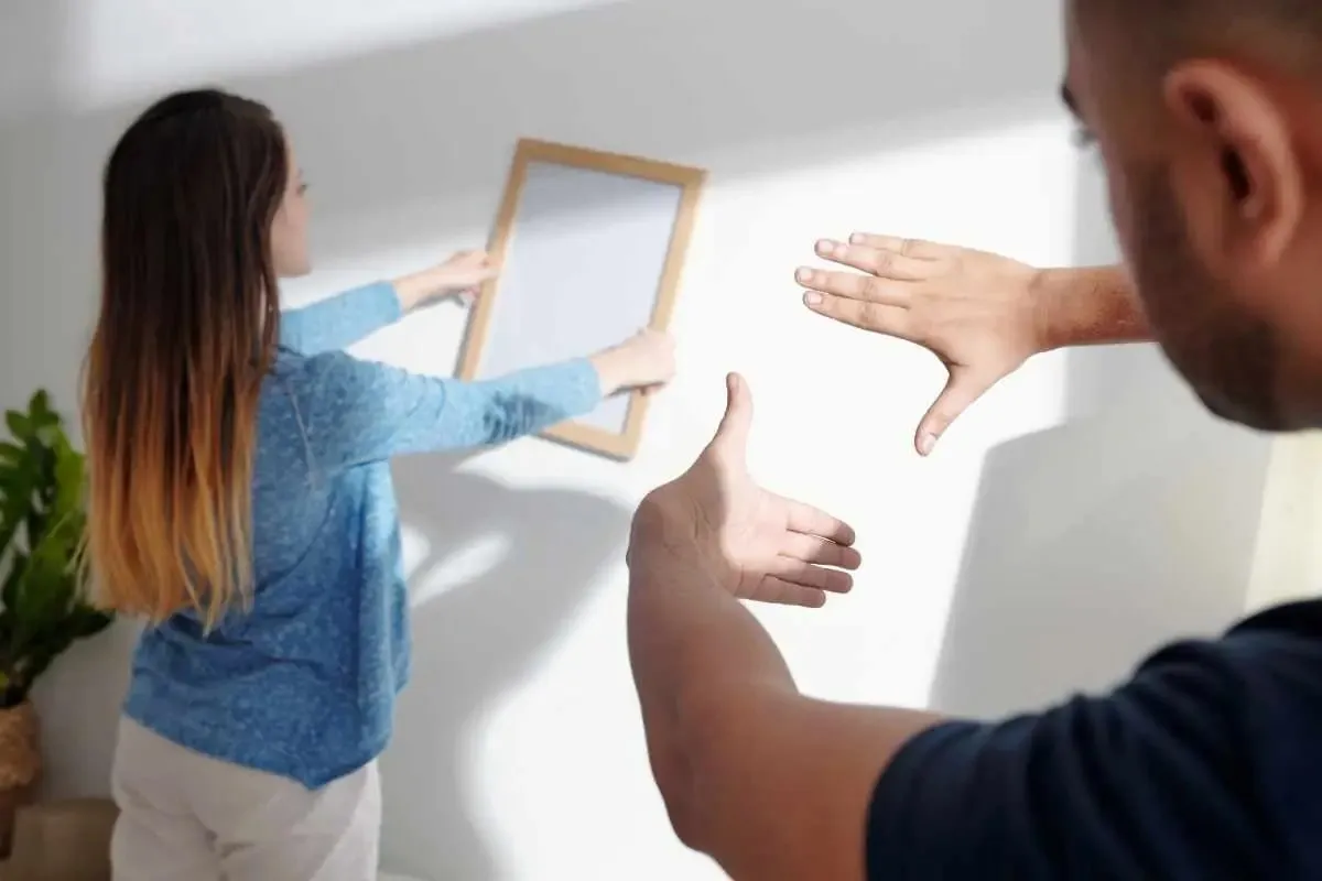 Stel hangt samen een lijst op aan de muur
