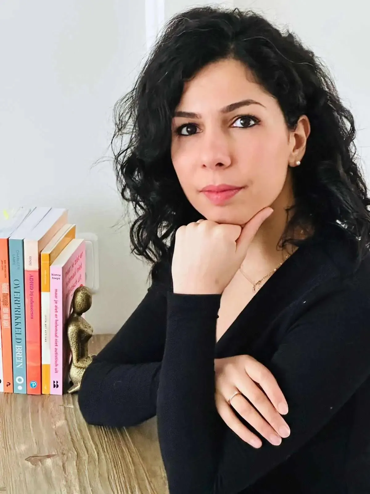 Zahra Talebi aan tafel naast boeken over ADHD en autisme